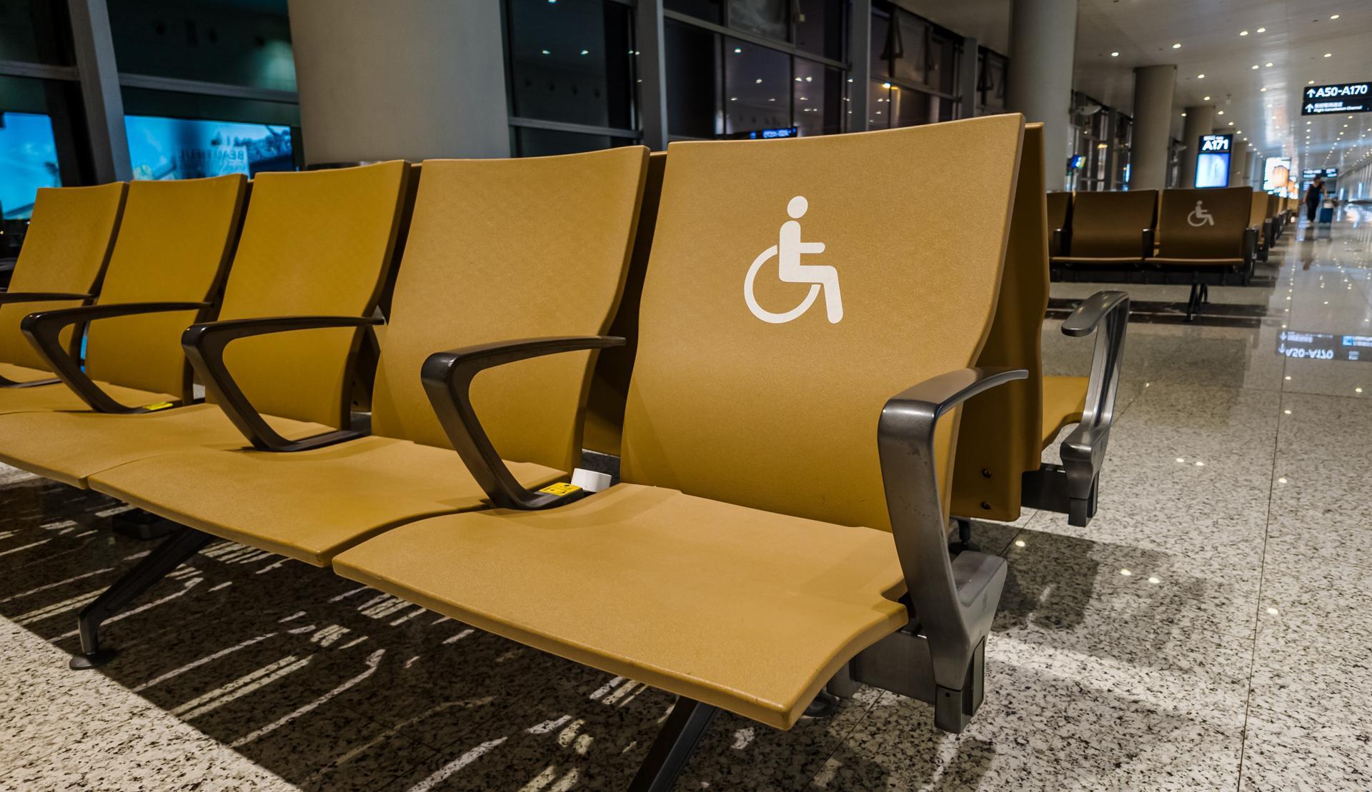 Accessible seating in a modern airport waiting area designated with a disability symbol, showcasing inclusivity and compliance with ADA standards Related concepts, accessibility, travel, ADA Awareness